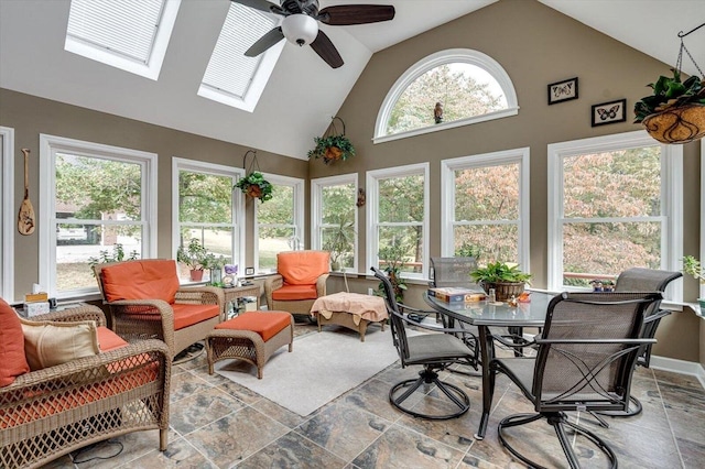 sunroom / solarium featuring ceiling fan and vaulted ceiling with skylight