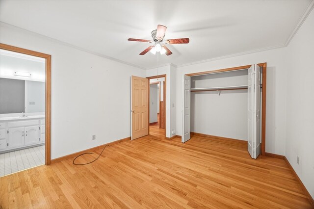 unfurnished bedroom with connected bathroom, baseboards, light wood-style floors, a closet, and crown molding