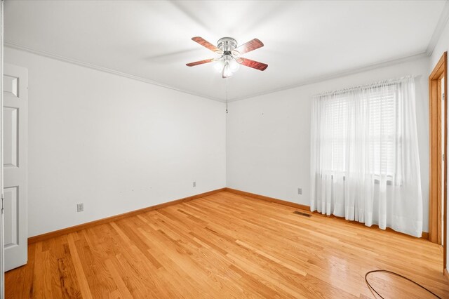 empty room featuring baseboards, visible vents, ceiling fan, and wood finished floors