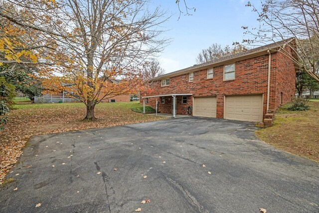 view of front of house with brick siding, an attached garage, and aphalt driveway