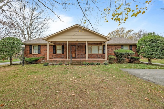 ranch-style home featuring a porch, a front lawn, and brick siding