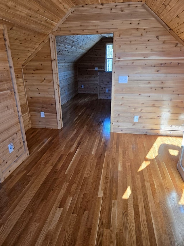 bonus room featuring lofted ceiling, wood walls, wooden ceiling, and wood finished floors