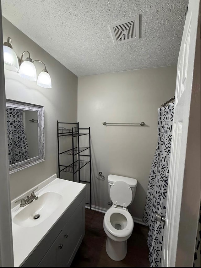 full bathroom with visible vents, a textured ceiling, toilet, and vanity