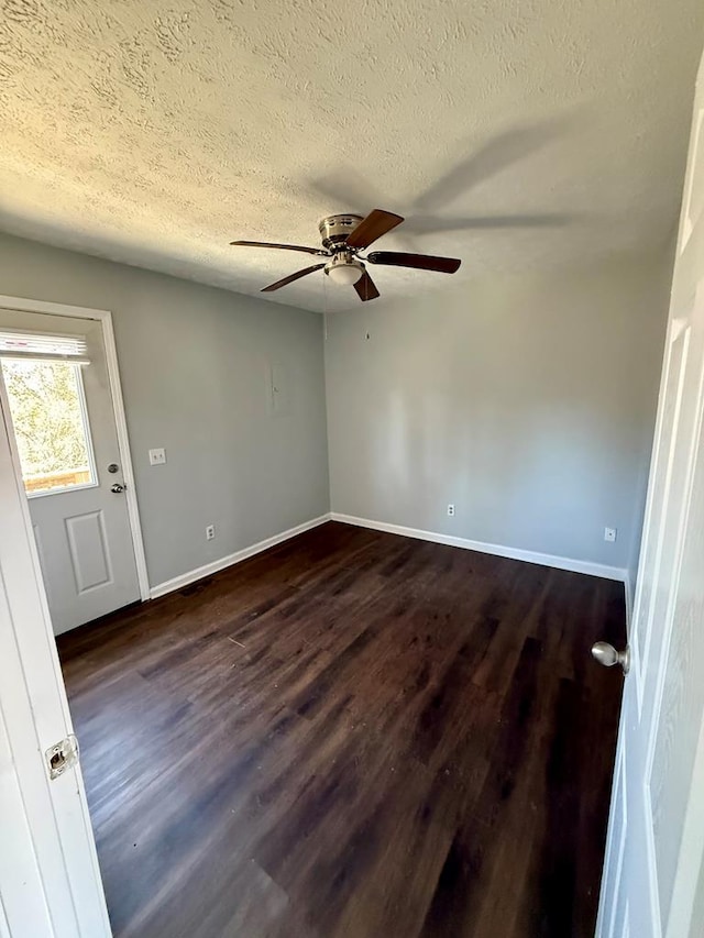 unfurnished room featuring dark wood finished floors, a ceiling fan, baseboards, and a textured ceiling