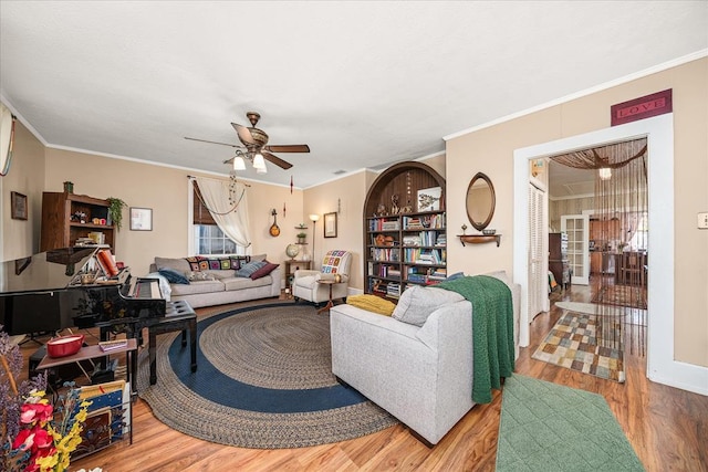 living area featuring a ceiling fan, crown molding, and wood finished floors