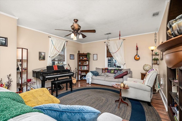 living area featuring crown molding, visible vents, ceiling fan, and wood finished floors