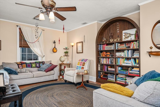 living room featuring ornamental molding, ceiling fan, a textured ceiling, and wood finished floors