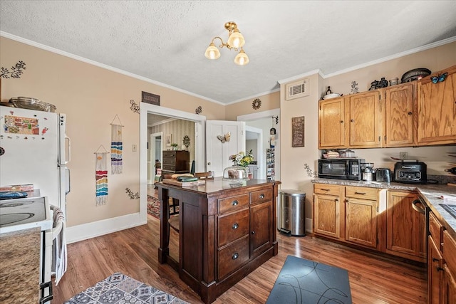 kitchen with crown molding, visible vents, a textured ceiling, wood finished floors, and white appliances