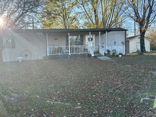 view of front of property with an outbuilding, covered porch, and a storage shed