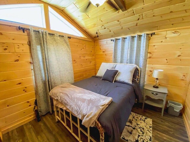 bedroom with vaulted ceiling, dark wood-style flooring, wood walls, and wood ceiling