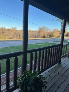 wooden deck with a water view and a porch