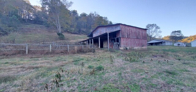 view of barn featuring fence