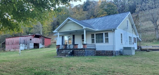 bungalow-style home featuring metal roof, crawl space, a porch, central AC, and a front yard