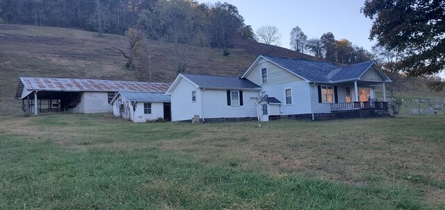 exterior space featuring covered porch, metal roof, and a lawn