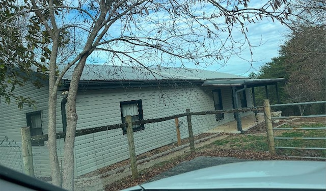 view of home's exterior with metal roof and fence