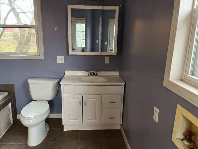 bathroom featuring baseboards, vanity, toilet, and tile patterned floors