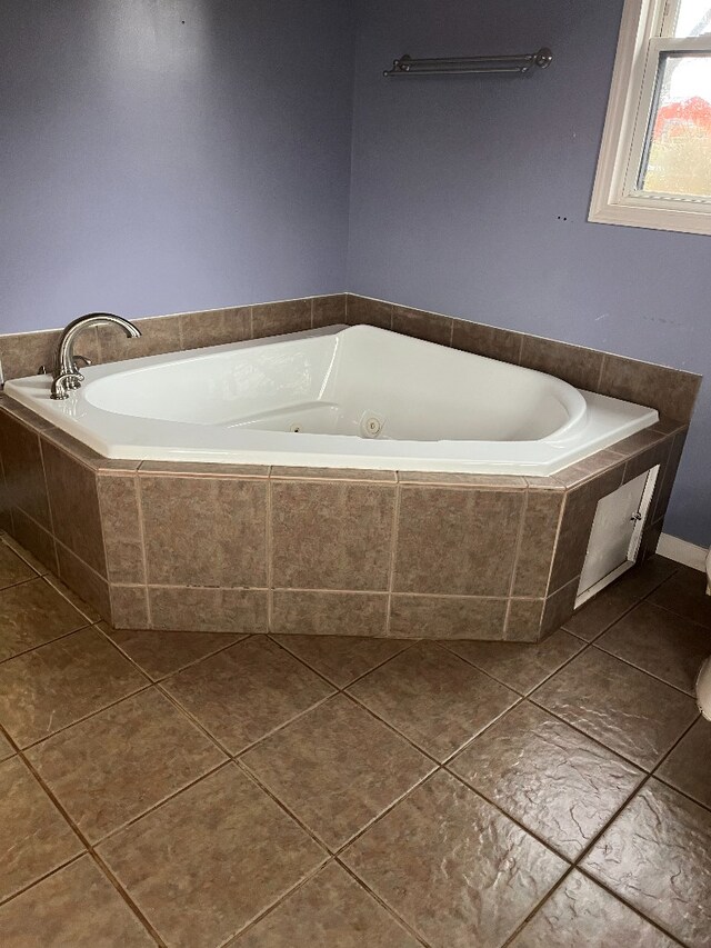 full bath with tiled tub and tile patterned floors