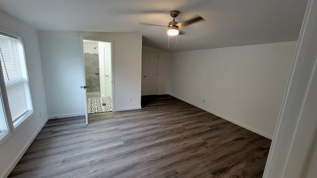 unfurnished bedroom with lofted ceiling, connected bathroom, wood finished floors, a ceiling fan, and baseboards