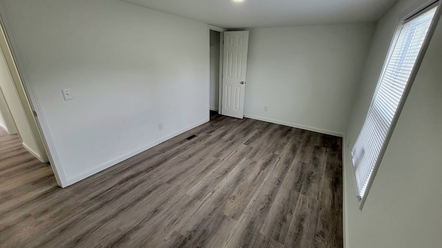 empty room featuring wood finished floors and baseboards