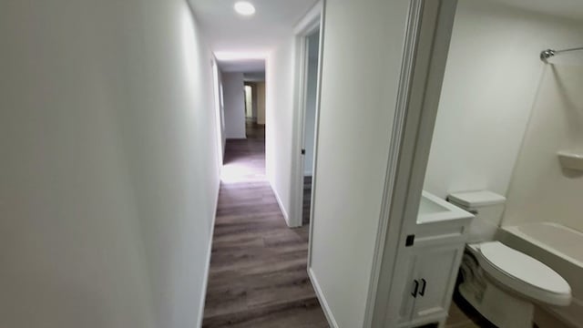 hall featuring wood finished floors and baseboards