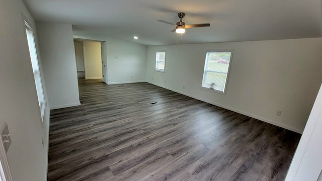 spare room with baseboards, dark wood finished floors, and a ceiling fan