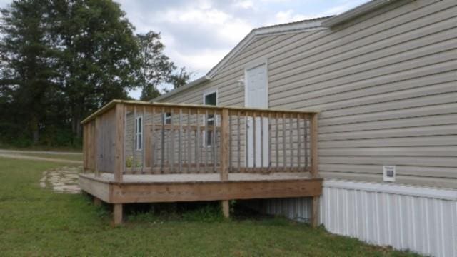 wooden terrace featuring a lawn