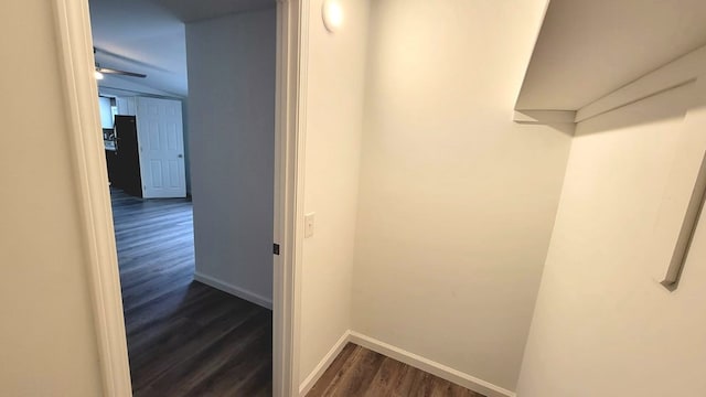 corridor featuring baseboards and dark wood finished floors