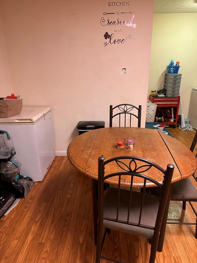 dining area with light wood-type flooring and baseboards