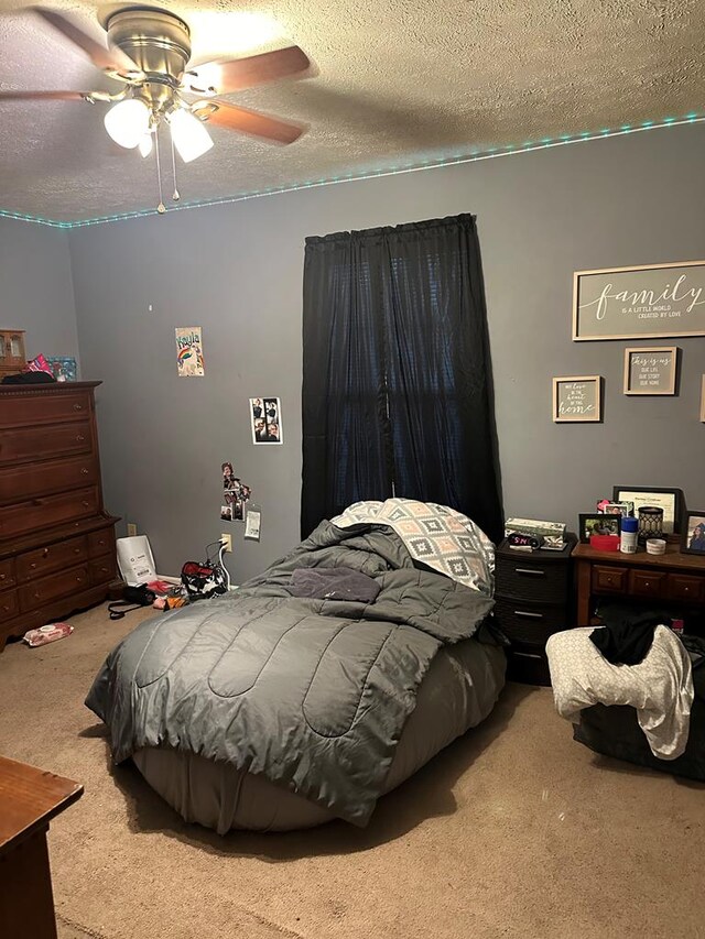 carpeted bedroom with a textured ceiling and ceiling fan