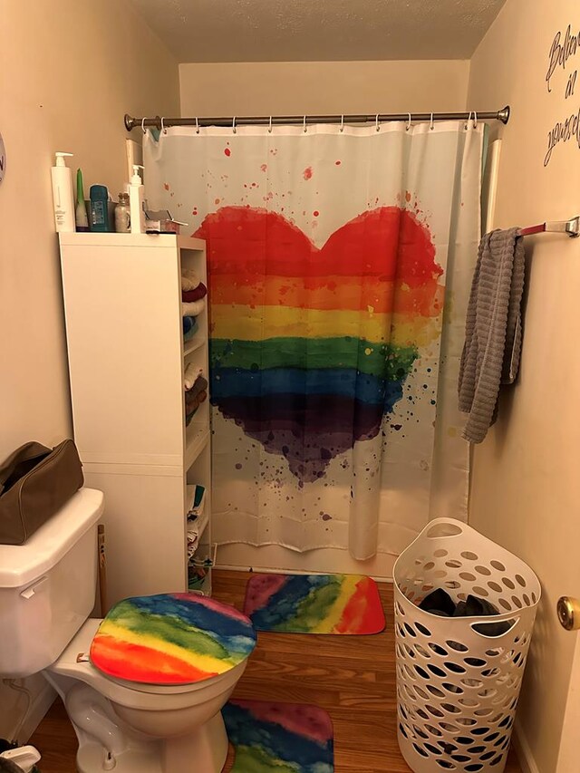 full bath with toilet, a shower with curtain, and wood finished floors