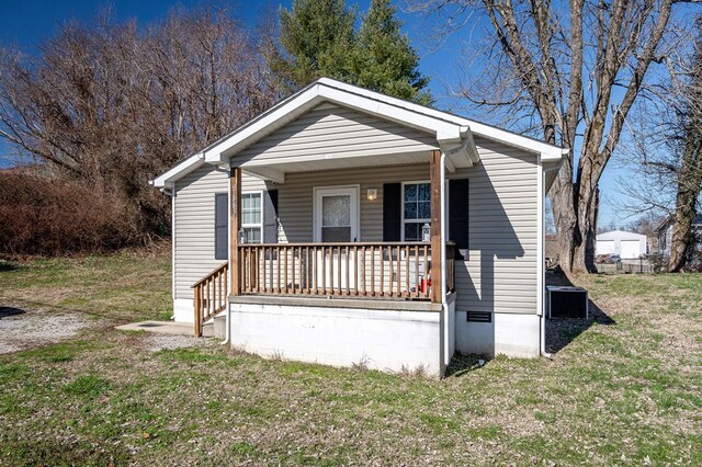 bungalow-style home with a front yard, covered porch, and crawl space