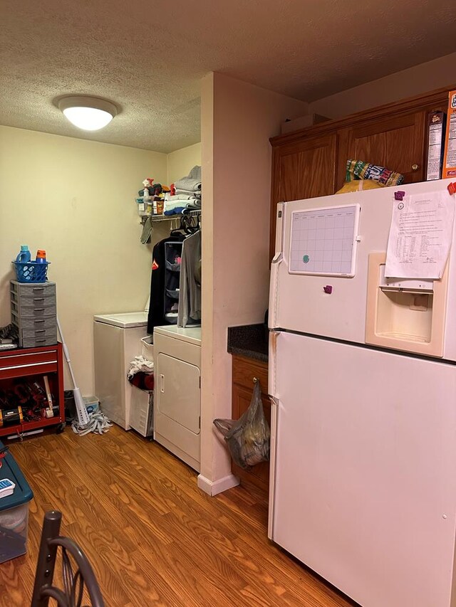 laundry room with a textured ceiling and wood finished floors