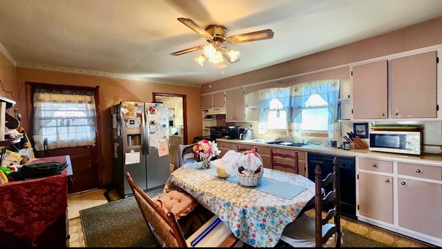 kitchen with black dishwasher, stainless steel refrigerator with ice dispenser, light countertops, a sink, and ceiling fan