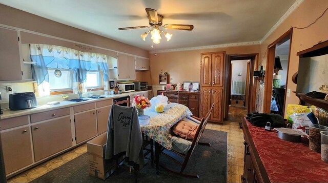 kitchen featuring ceiling fan, light countertops, white microwave, and crown molding