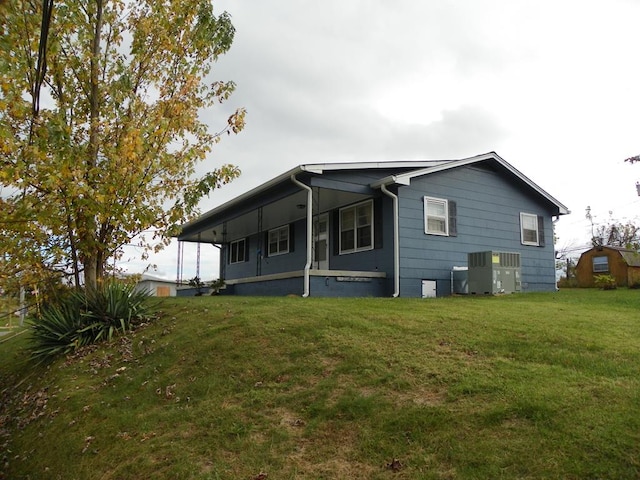 view of home's exterior with a lawn and central AC unit