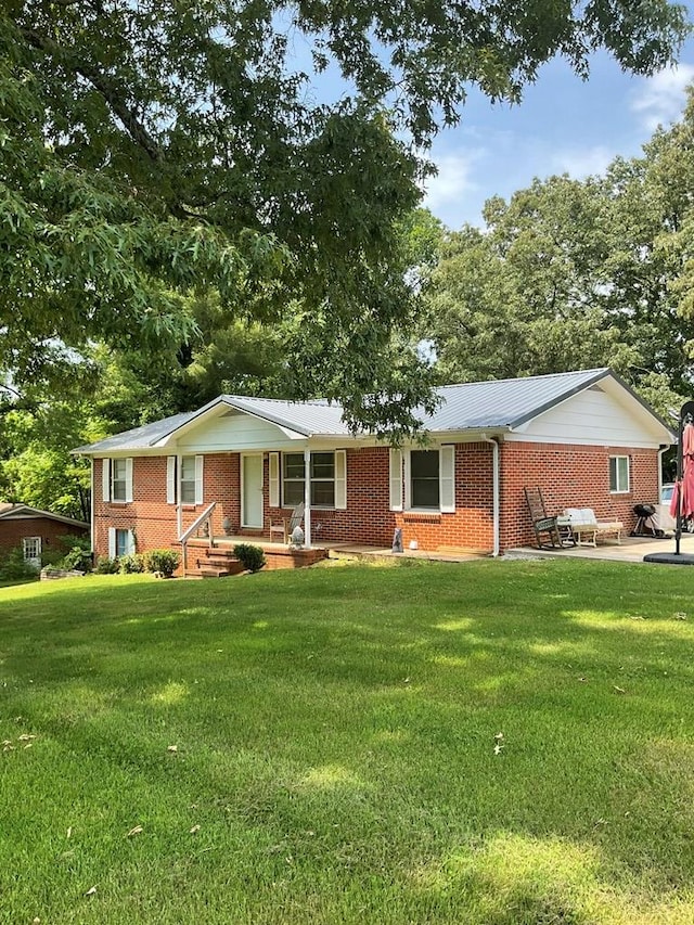 single story home with a porch, a front lawn, and brick siding