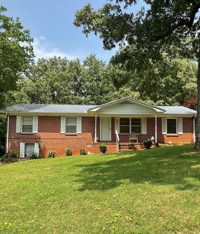 single story home with a porch, brick siding, and a front lawn