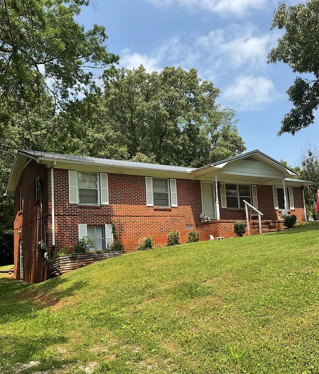 ranch-style house featuring a front lawn, a porch, and brick siding