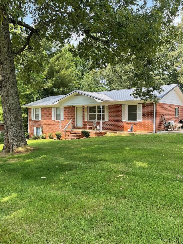 ranch-style home with covered porch, a front lawn, and brick siding