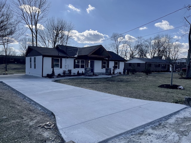 single story home featuring concrete driveway and a front yard