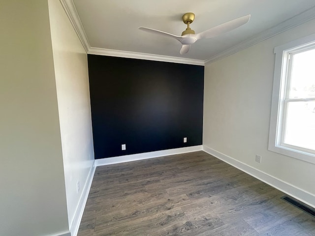 unfurnished room with crown molding, dark wood-type flooring, visible vents, and a healthy amount of sunlight