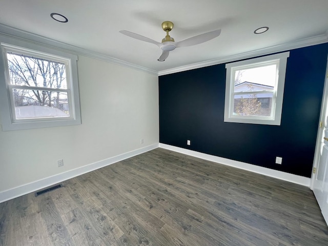 spare room featuring baseboards, visible vents, dark wood finished floors, and crown molding