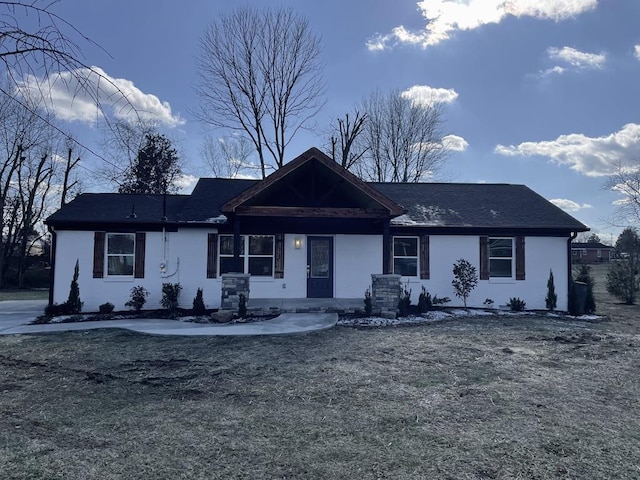 ranch-style home with stucco siding and a front yard