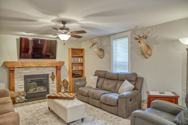 living room with a fireplace, wood finished floors, and a ceiling fan