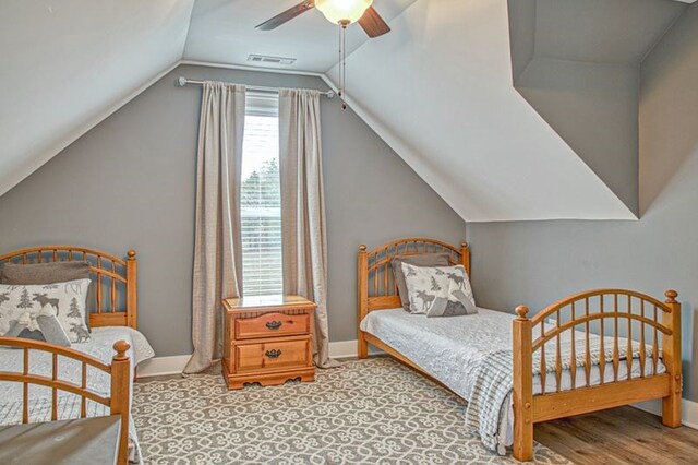 bedroom featuring a ceiling fan, visible vents, vaulted ceiling, and baseboards