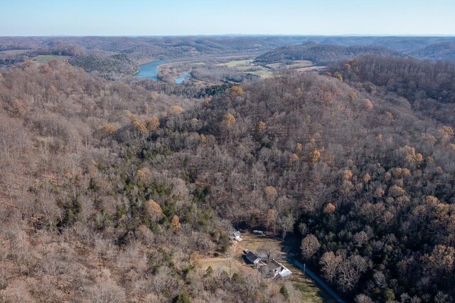 drone / aerial view featuring a water view and a wooded view