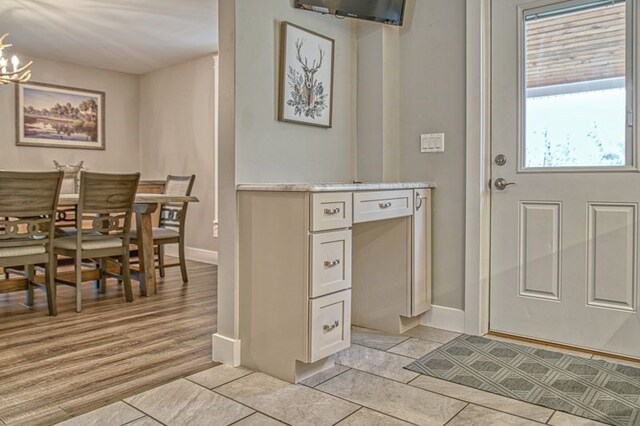 interior space with a chandelier, baseboards, and light wood finished floors