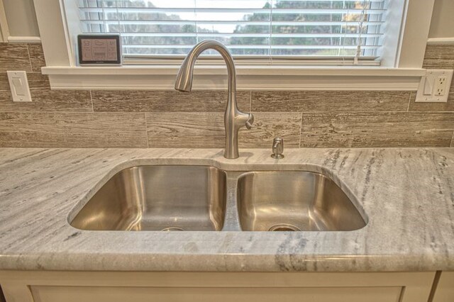 interior details featuring light stone countertops and a sink