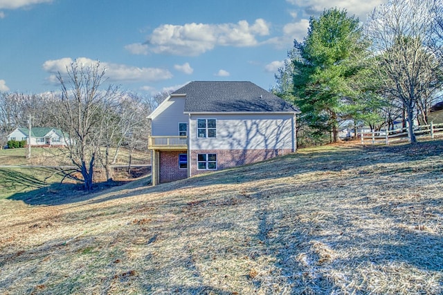 rear view of property featuring brick siding and a lawn