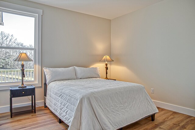 bedroom with baseboards and wood finished floors